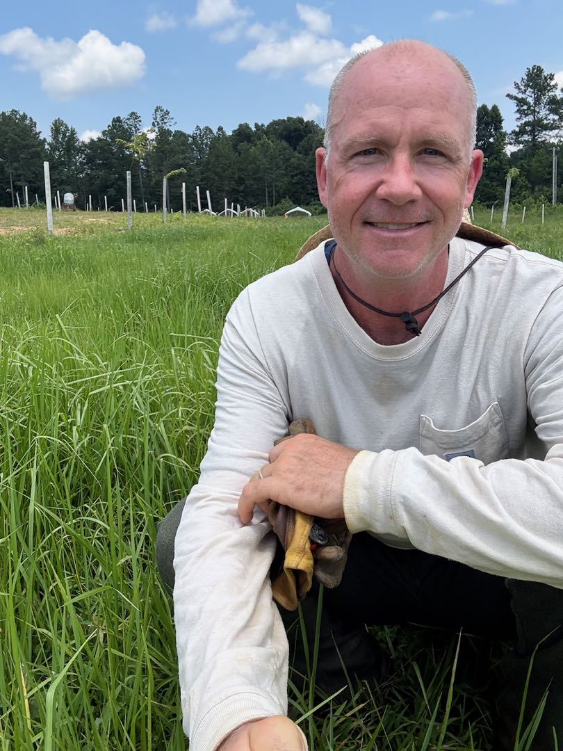 Rolf with work gloves standing on well-kept pasture